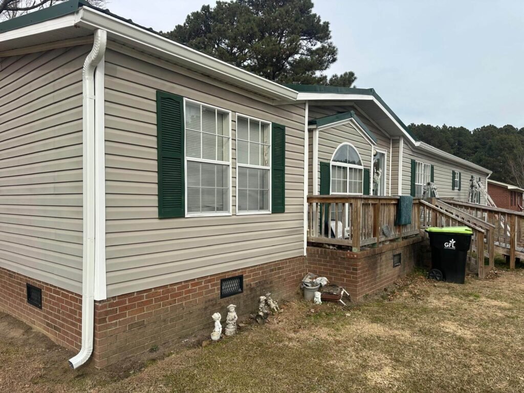 Close view of seamless gutter and downspout installation on manufactured home in Conway NC