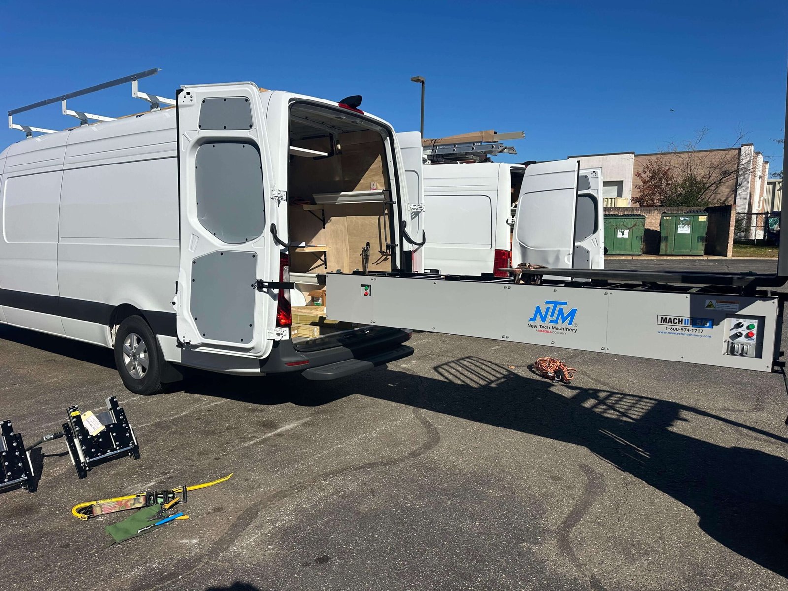 Seamless gutter extrusion machine and service truck preparing on-site custom gutter fabrication.