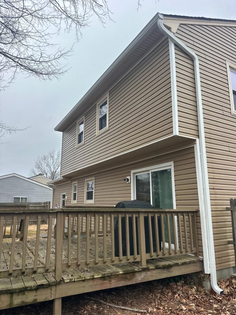 White seamless gutter system with properly aligned downspout installed in Newport News Virginia
