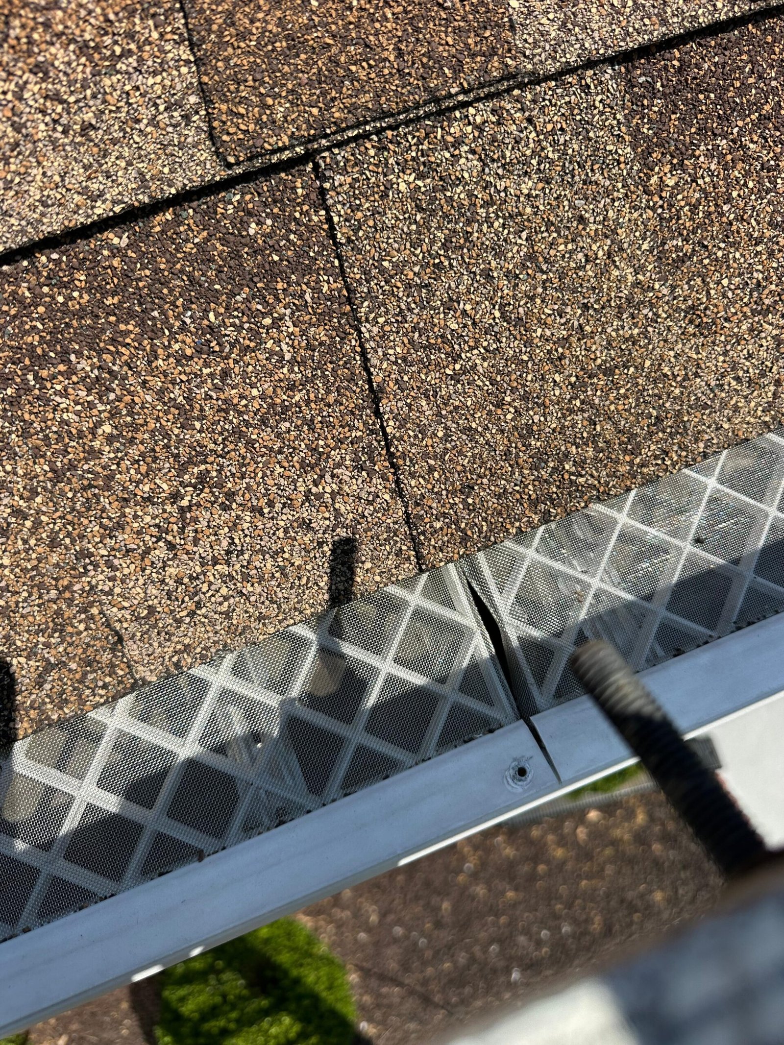 Visible gap at the gutter filter joint. Two sections are not overlapping or seated against each other, leaving the gutter fully exposed at this point.