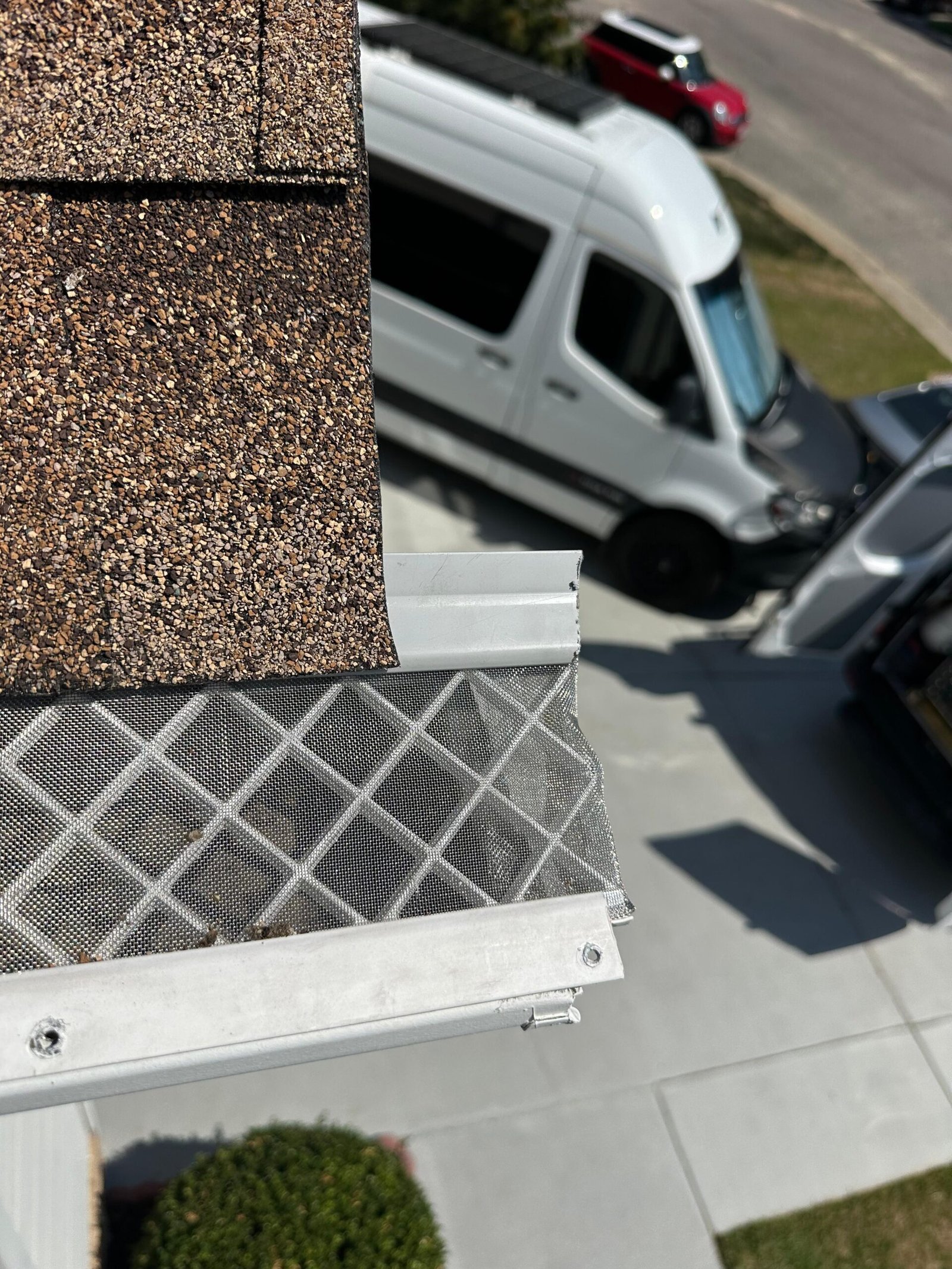 Filter section extending well beyond the outer gutter edge. Excess material catches wind, lifts the filter, and signals the section was never cut or fitted to the channel.