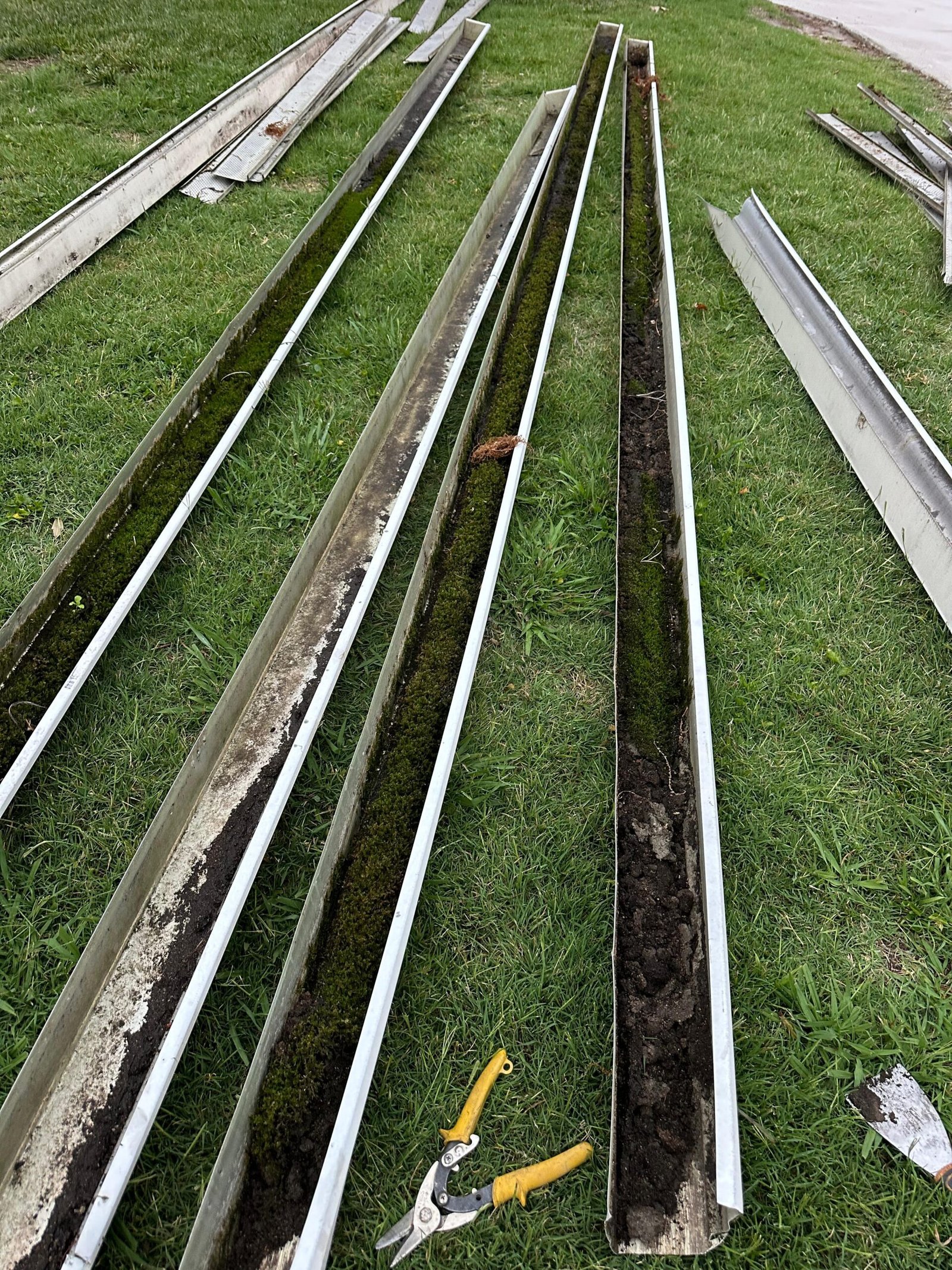 seamless gutter installation Chesapeake VA — old gutters removed showing interior packed with moss and compacted dirt after 20 years