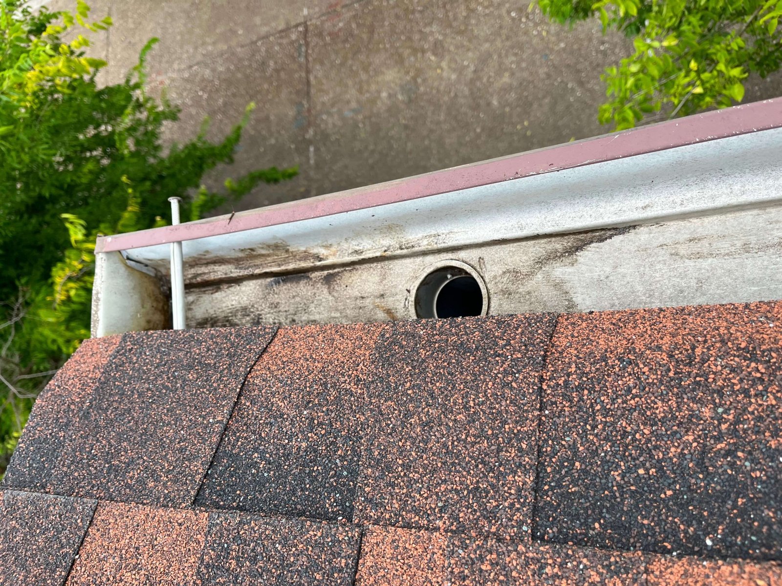 Rust hole repair during second-story gutter cleaning on a Virginia Beach home