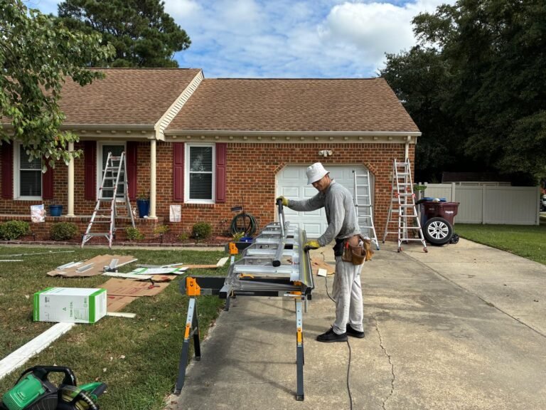 Technician forming aluminum trim coil on-site for fascia wrap in the driveway of a Chesapeake, VA home