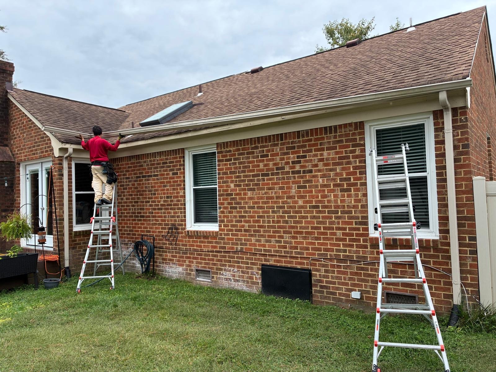 Technician detaching a long gutter run to access the fascia in Chesapeake, VA