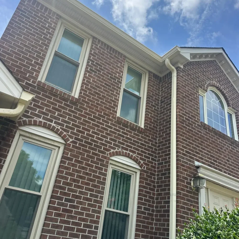 New gutter installation on a Virginia Beach two-story home for improved rainwater drainage and roof protection.