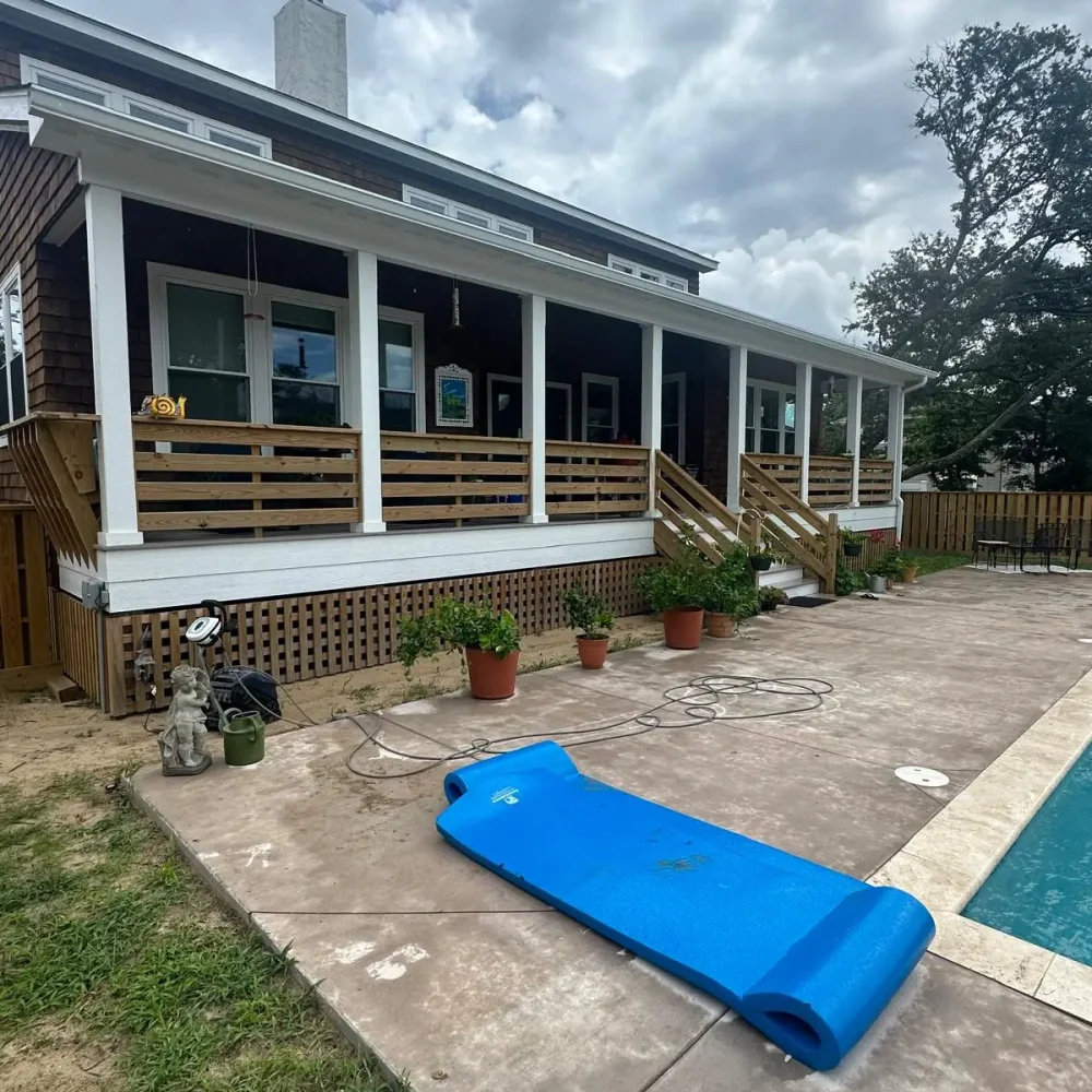 Chesapeake house with seamless gutter installation along porch and pool area for long-lasting water management.