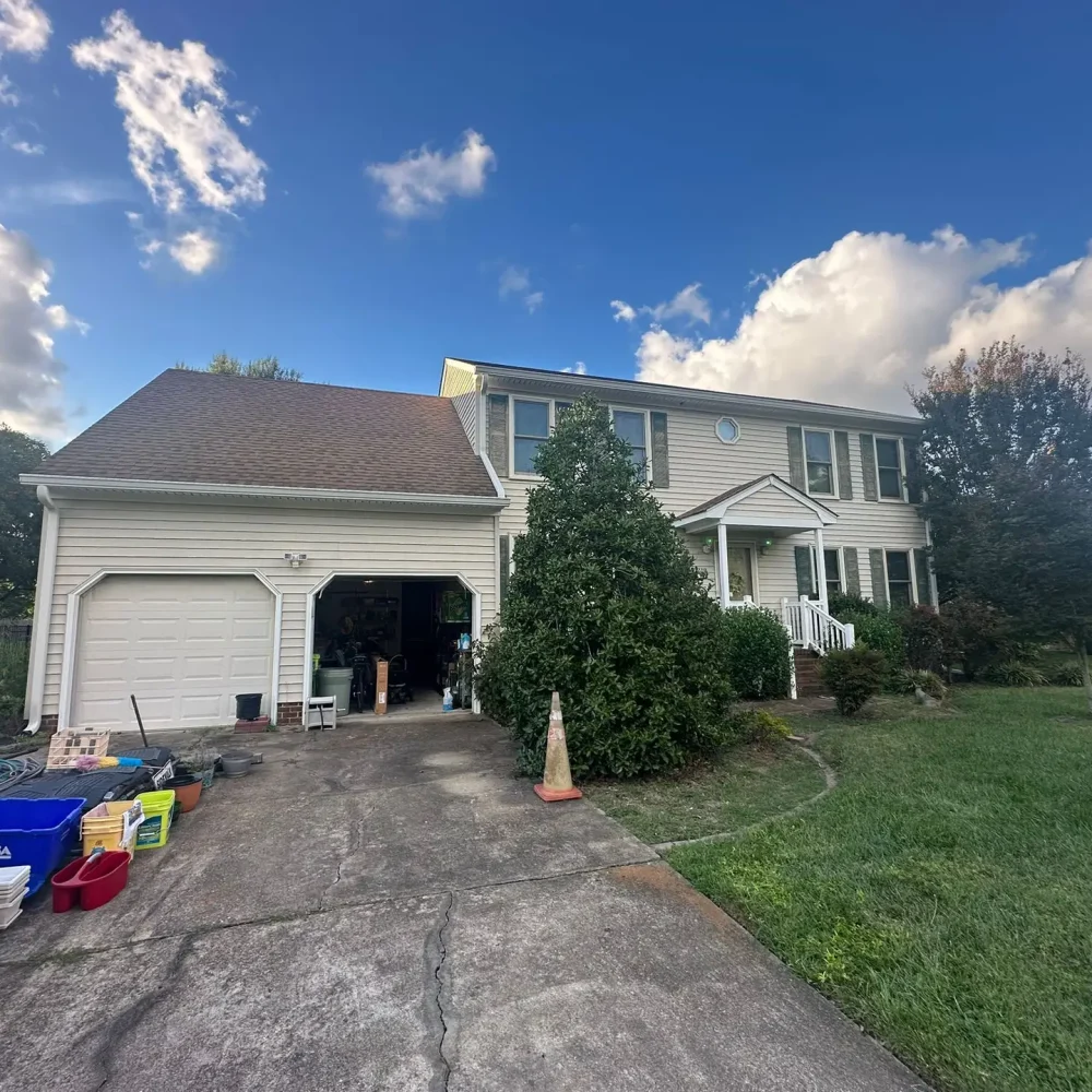 Custom gutter installation with filters for a suburban home driveway in Newport News to prevent clogs and leaks.