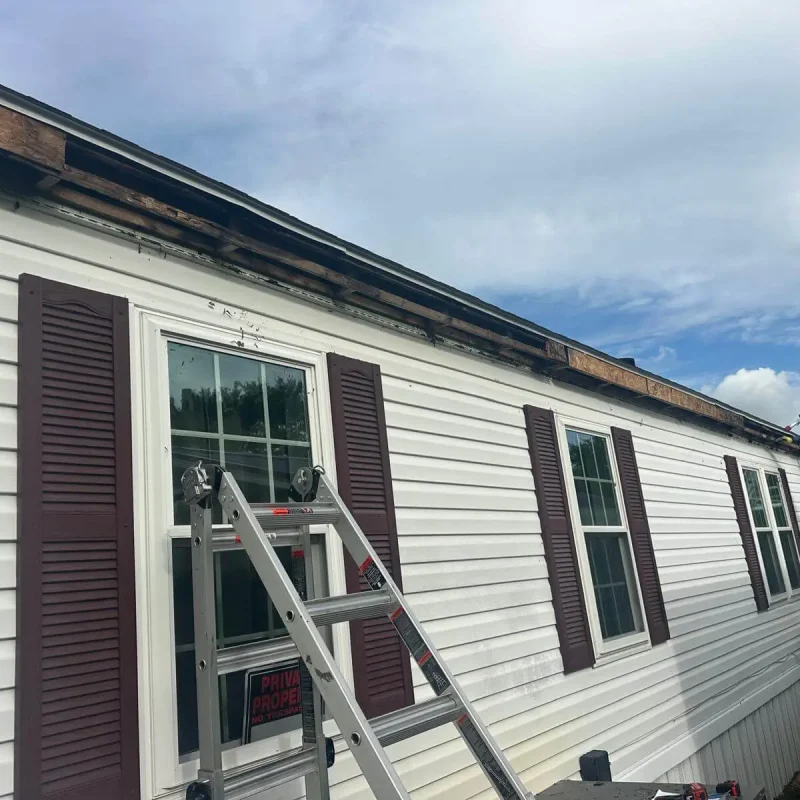 Severely damaged fascia board being removed and repaired before installing new seamless gutters