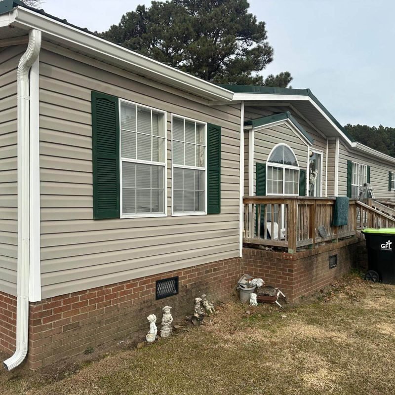 Close view of seamless gutter and downspout installation on manufactured home in Conway NC