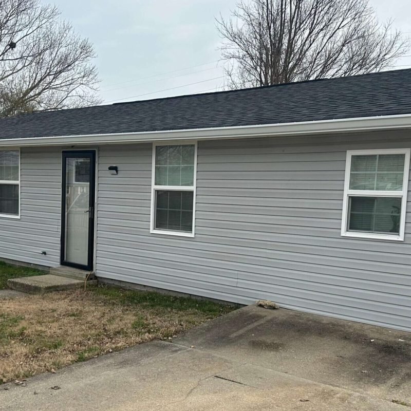 Single-story home with newly installed seamless gutter system along roofline.