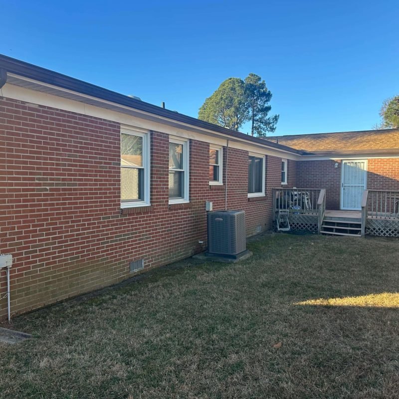 Aging sectional gutters on a brick home in Portsmouth VA before gutter replacement project