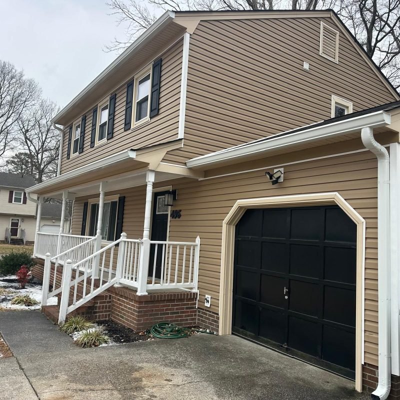 Seamless gutter installation above garage replacing old sectional gutters in Newport News VA