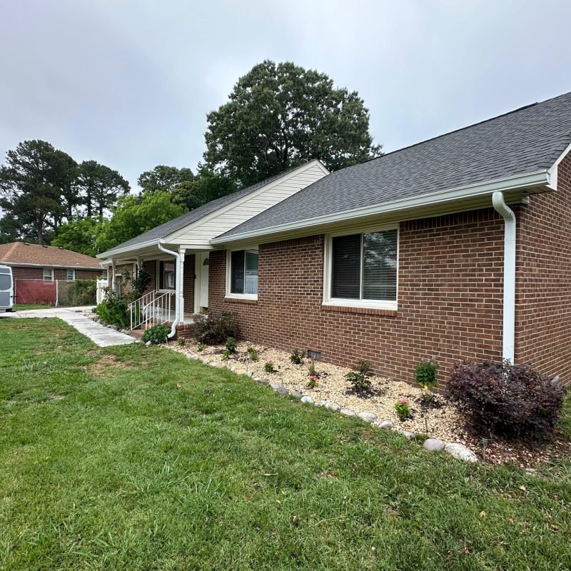 completed seamless gutter installation side elevation brick ranch home Chesapeake VA — Gutter Masters Pro van visible