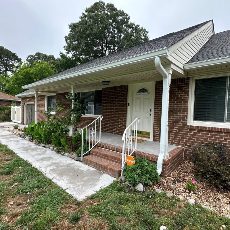 new white seamless gutters installed on rear elevation of brick ranch home — Norfolk VA gutter installation completed